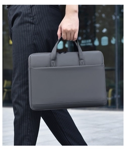 Close-up of a dark grey waterproof laptop bag with professional fabric texture and front pocket
