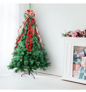 Vue détaillée du grand sapin de Noël avec des nœuds rouges et verts festifs au sommet