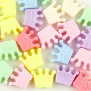 Macro shot of colorful crown-shaped DIY beads in pastel pink yellow and blue matte finish