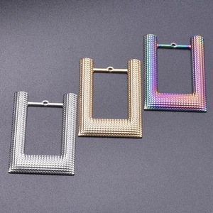 Detailed view of U-shaped stainless steel charms with dot texture in silver, gold and rainbow