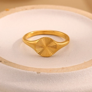 Minimalist 18K gold plated stainless steel sunburst signet ring on a ceramic tray