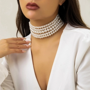 Detail of elegant 5-row faux pearl choker necklace on a white deep V-neck dress