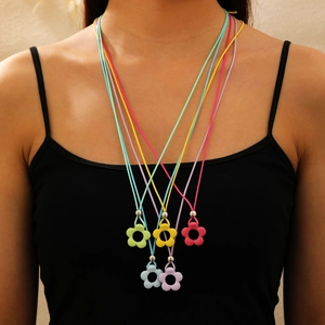 Set mit fünf bunten Blumenhalsketten aus Harz und gewebten Schnüren an einem Model