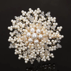 Macro shot of luxury handmade snowflake brooch with white pearls and crystals