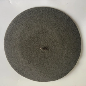 Top down detail of dark grey wool felt beret with classic stem on white background