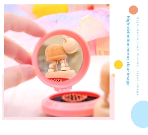 Pink portable folding mirror with handle showing clear reflection for travel