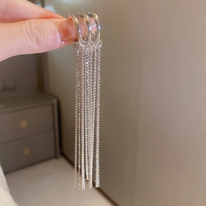 Macro detail of long silver fringe earrings with hanging beaded tassel chains
