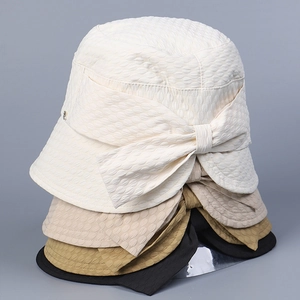 Detailed stack of four colorful bow sun hats showing fabric texture and elegant side design