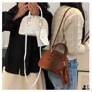 Detail of shell-shaped bags with crocodile pattern and matching small pouch attachments