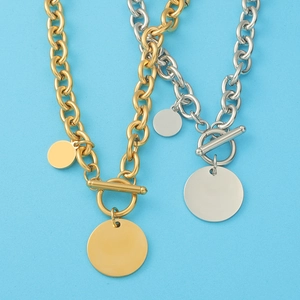 Detail of gold and silver chunky chain necklaces with OT buckles and round pendants