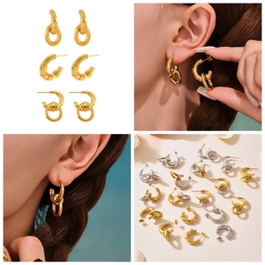 Detailed view of C-shaped irregular gold and silver earrings on a summer beach background