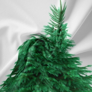 Dettaglio dell'arazzo natalizio bohémien con trama di aghi di pino verde e tessuto naturale