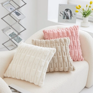 Luxurious PV velvet striped throw pillows in cream, camel, and pink on a cozy sofa