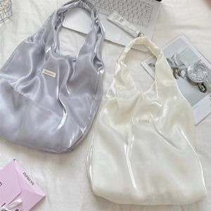 Detailed view of silver and white satin tote bags with sleek metallic luster and soft texture