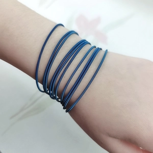 Close-up of blue multi-strand stainless steel wire bracelet worn on a woman's wrist