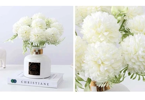 Detailed macro view of white artificial chrysanthemum flowers in a modern white ceramic vase