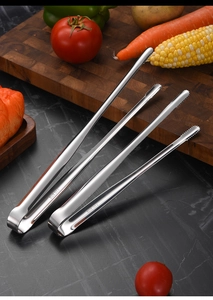Detail of two SUS 304 stainless steel food tongs with serrated tips on a dark slate surface