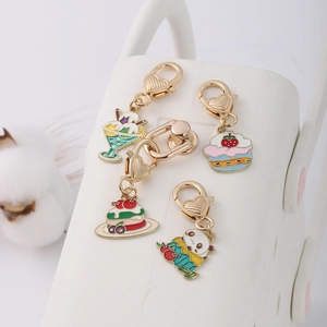 Detail of four golden enamel dessert pendants with heart lobster clasps for DIY crafts