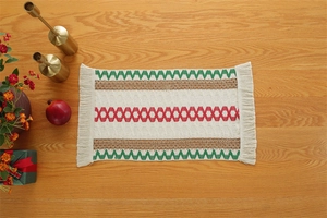 Macro detail of Christmas cotton linen table runner with woven geometric patterns and tassels