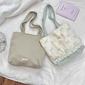 Detailed top view of plaid and bow-printed canvas tote bags with delicate lace trim