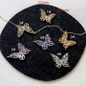 Detailed macro view of 14k gold plated butterfly charms with zircon inlays for jewelry DIY