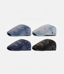 Detail of vintage denim flat caps featuring colorful letter embroidery and adjustable buckles