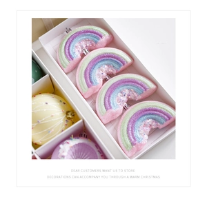 Close-up of glittery macaron rainbow ornaments in a festive gift packaging box