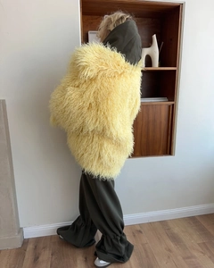 Rear view of yellow faux fur coat showing oversized texture and long fiber plush material
