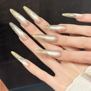 Luxury champagne gold cat-eye stiletto press-on nails with golden lines and rhinestones
