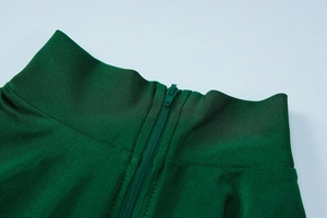 Detail eines dunkelgrünen Jumpsuits mit Stehkragen und hochwertigem Reißverschluss