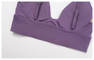 Detail of purple ribbed yoga top featuring adjustable straps and reinforced stitching