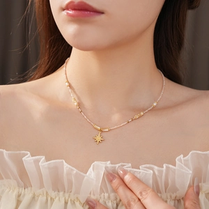 Close-up of starburst pendant necklace with freshwater pearls on a model's neck