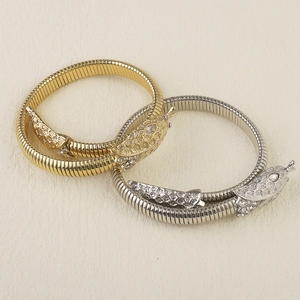 Macro shot of flexible tubogas snake bracelets with sparkling crystal heads in gold and silver