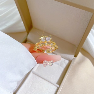 Elegant gold crown open ring with zircon crystals in a luxury jewelry box