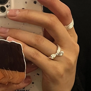 Close-up of S925 sterling silver bow knot ring and multi-layer minimalist bands