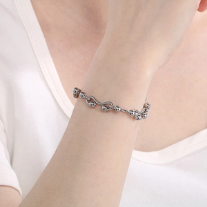 Close-up of minimalist silver stainless steel chain link bracelet on a woman's wrist