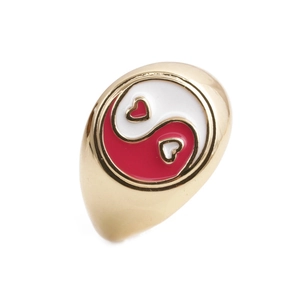 Macro detail of gold-plated star ring featuring red and white yin-yang heart enamel design