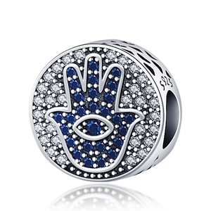 925 silver Hamsa hand and Evil Eye charm with blue cubic zirconia on white background
