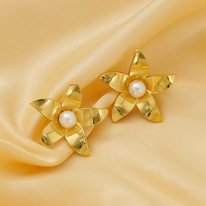 Golden flower earrings with pearls on champagne silk fabric background