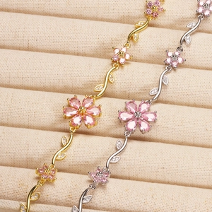Close-up of pink zircon flower bracelets with leafy vines in gold and silver