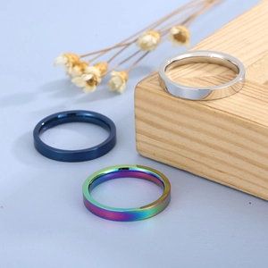 3mm minimalist stainless steel rings in silver, blue, and rainbow colors on wood