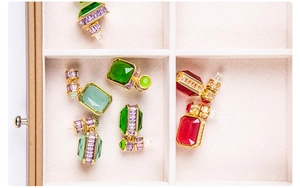 Detailed view of vintage geometric drop earrings with emerald and ruby gemstones