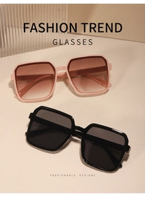 Nahaufnahme einer quadratischen Übergroße Sonnenbrille in Rosa und Schwarz auf einer Fläche