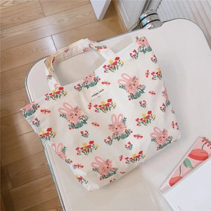 Close-up of pink rabbit and floral print on white cotton bag with simple wish label