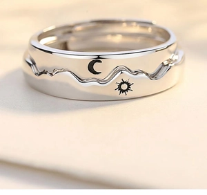 Macro view of interlocking silver rings with sun and moon icons for couples