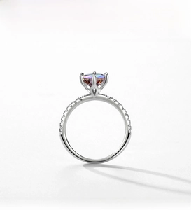Macro detail of S925 silver ring featuring a four-prong set rainbow gemstone and pavé diamonds