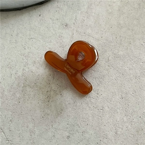 Detailed view of an amber acetate hair claw clip with golden Sunshine Handmade text
