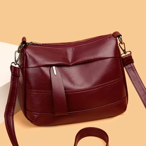 Sac bandoulière minimaliste en cuir souple bordeaux avec fermetures éclair multicouches