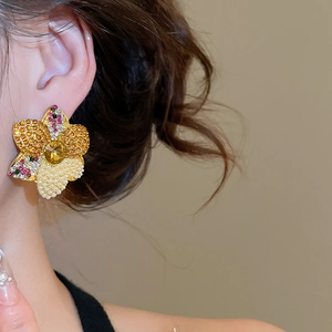 Macro shot of an elegant vintage floral earring with yellow crystals and pearl beadwork