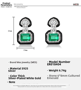 Macro detail of Art Deco S925 silver emerald drop earrings with black enamel framing